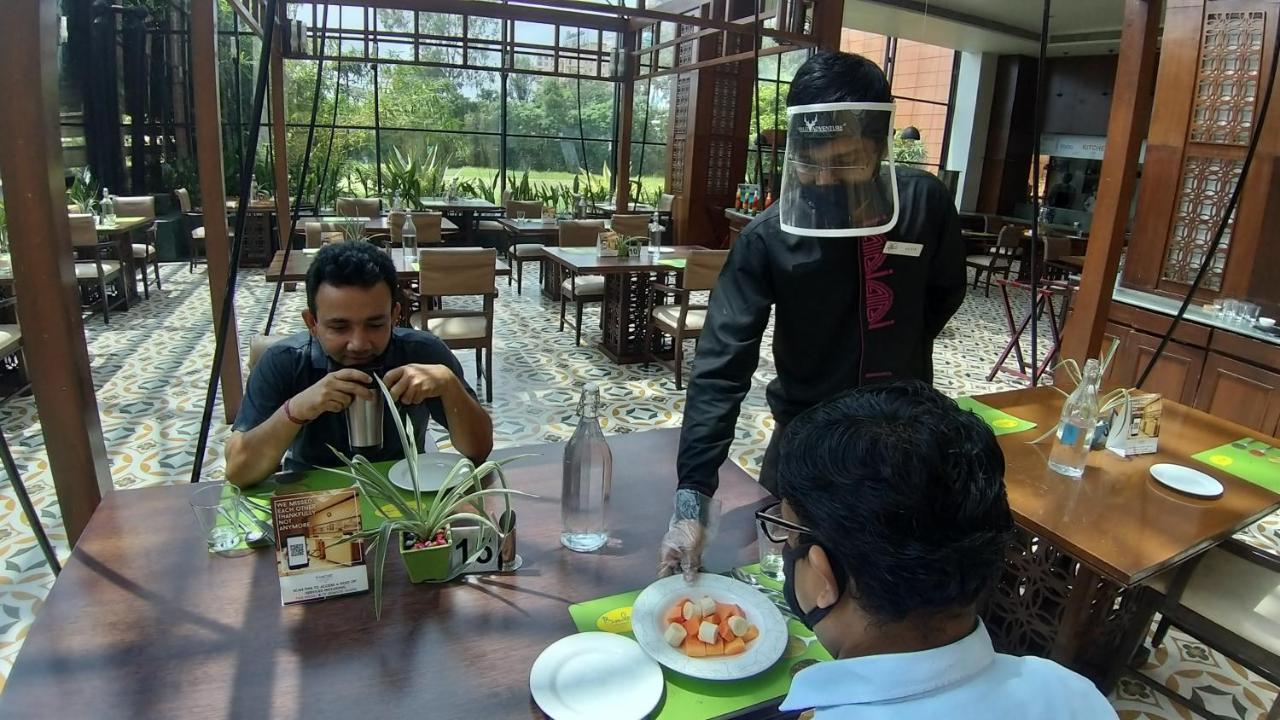 The Orchid Hotel Hinjewadi Pune Ngoại thất bức ảnh A restaurant in India with a waiter wearing a face shield